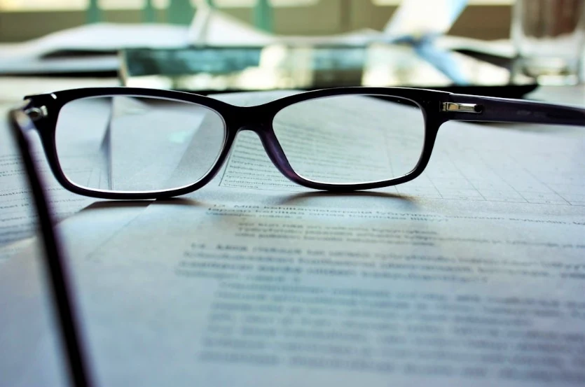 Lunettes posées sur des documents en cours d’analyse